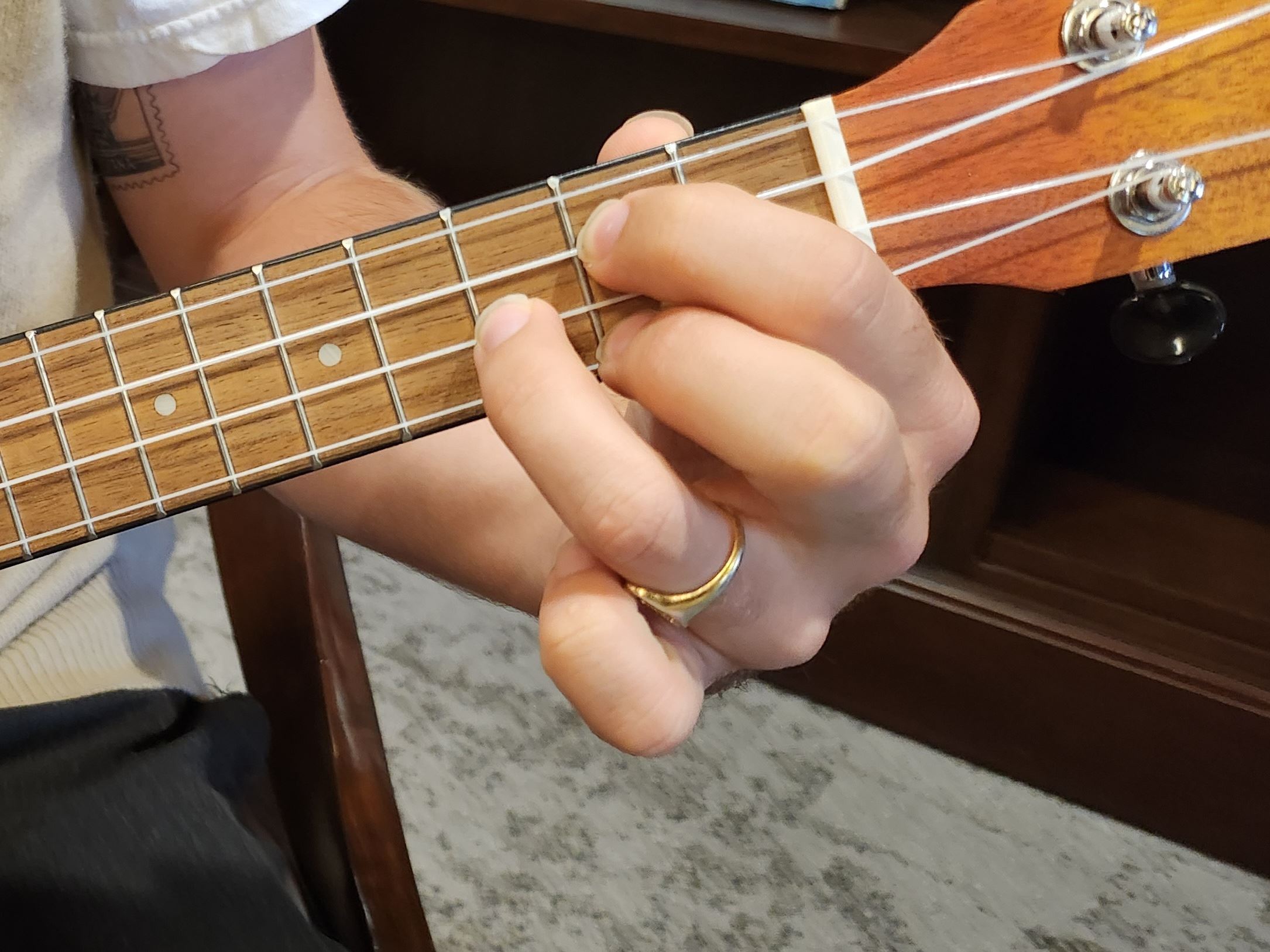 Person playing G on the ukulele