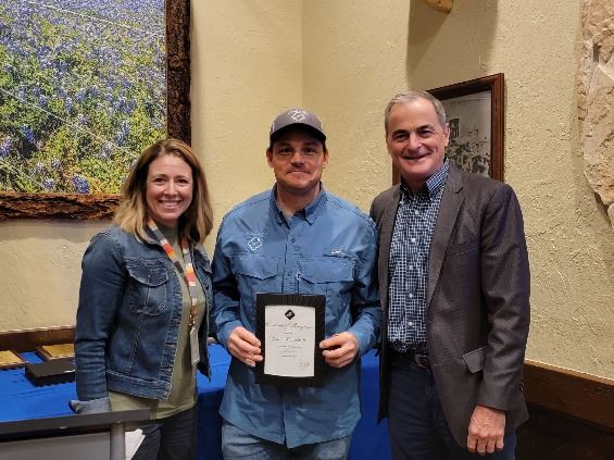 Three people grouped together, smiling at the camera